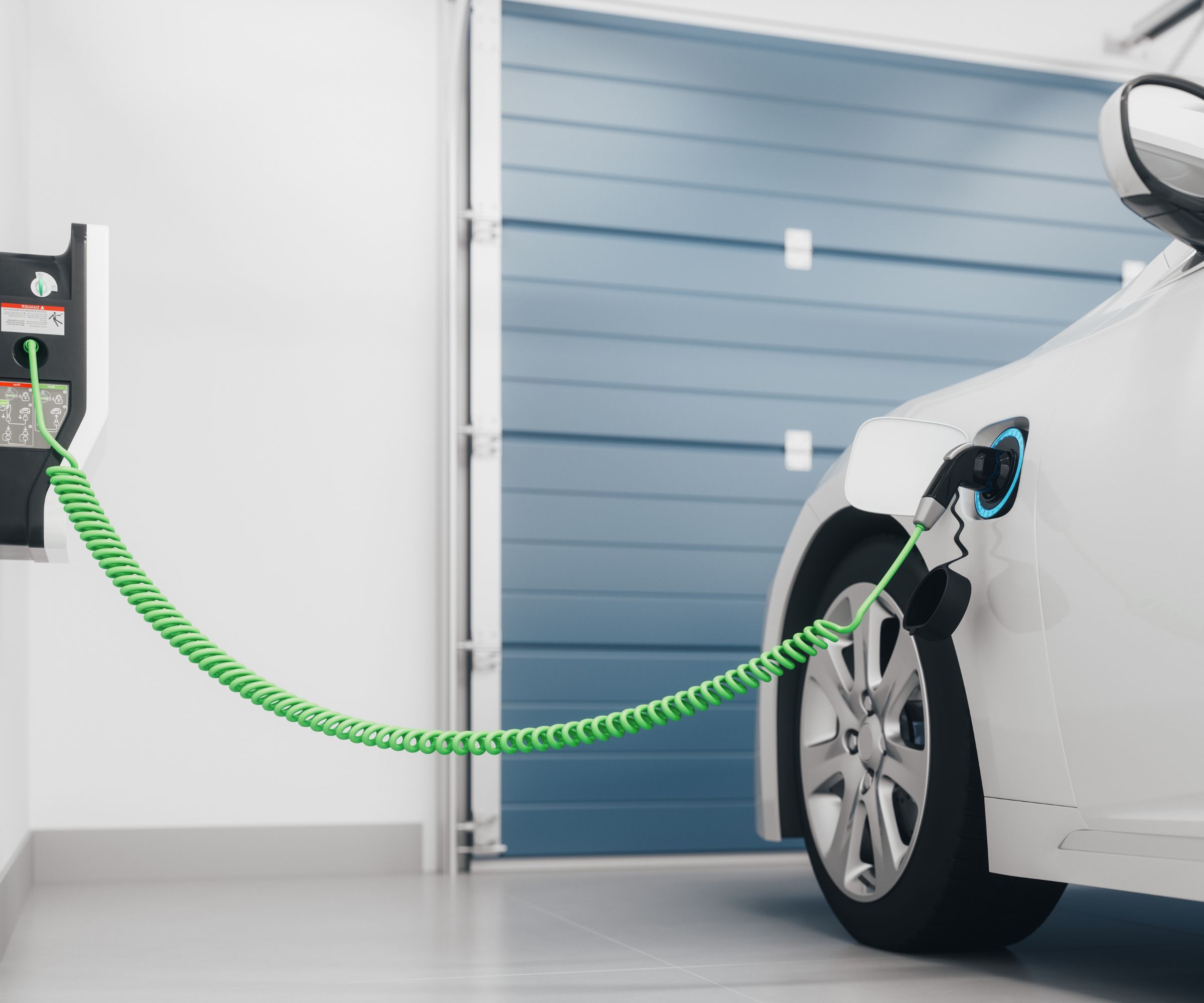 Une borne de recharge pour voiture électrique fixée au mur d'une maison dans un garage, un câble vert chargeant une voiture blanche